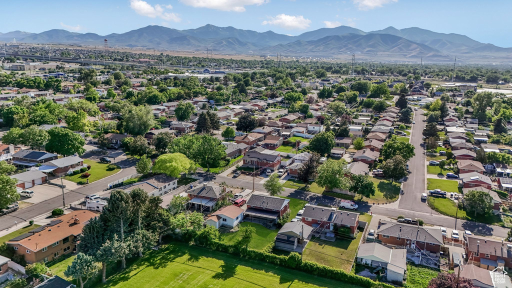 Aerial view of property and surrounding area with a mountainous background and nearby suburban area