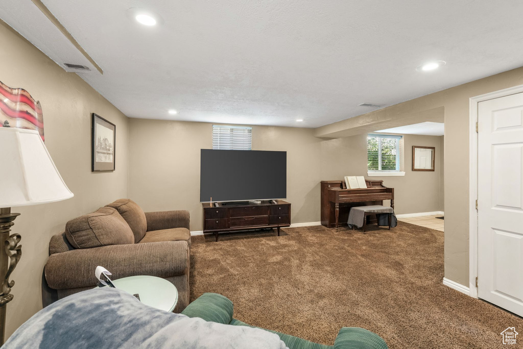 Carpeted living area featuring recessed lighting and baseboards