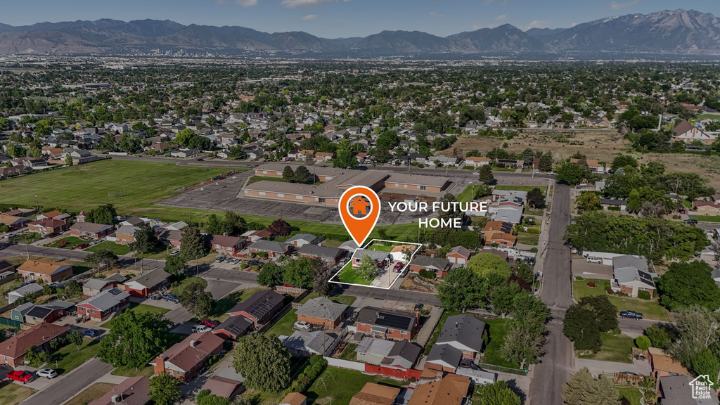 Aerial view of property and surrounding area featuring a mountainous background and property parcel outlined