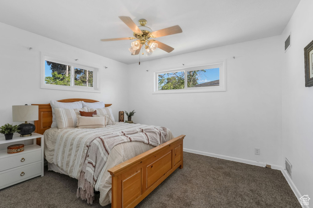 Carpeted bedroom featuring baseboards and a ceiling fan