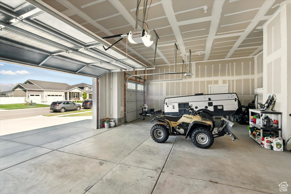 Garage featuring a garage door opener and a residential view