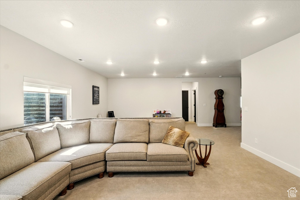 Living room with recessed lighting, light colored carpet, and baseboards