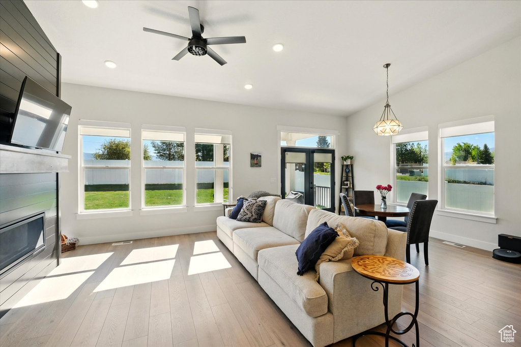 Living room featuring a fireplace with flush hearth, wood finished floors, recessed lighting, ceiling fan, and baseboards