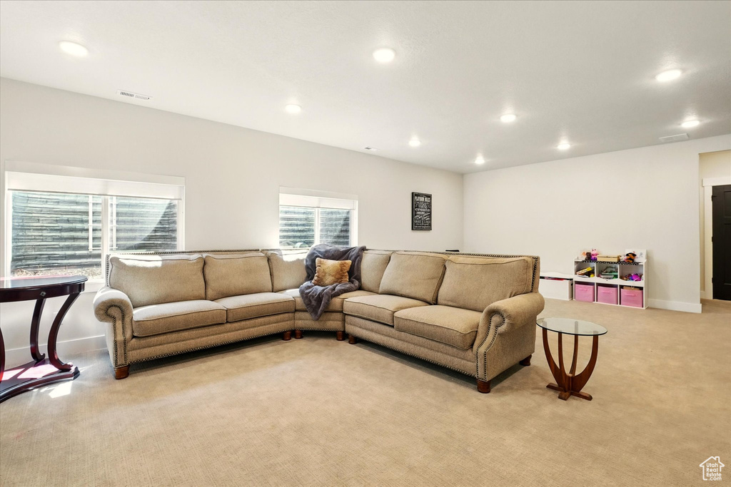 Living area featuring light colored carpet, recessed lighting, and baseboards