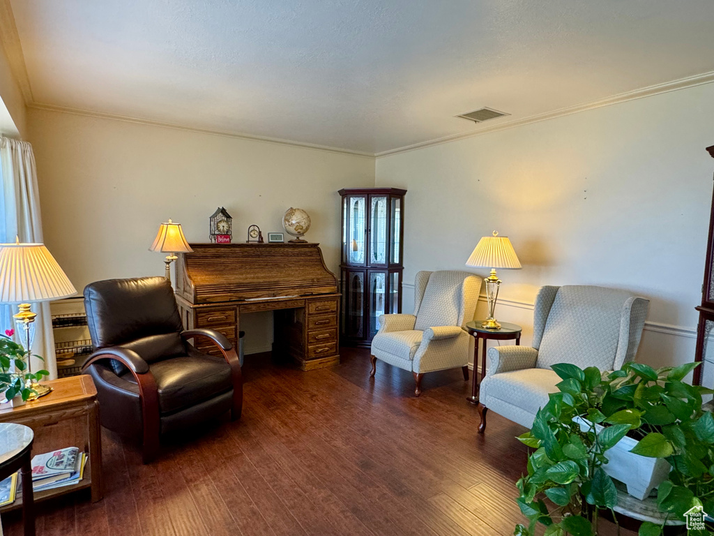 Sitting room with wood finished floors and crown molding