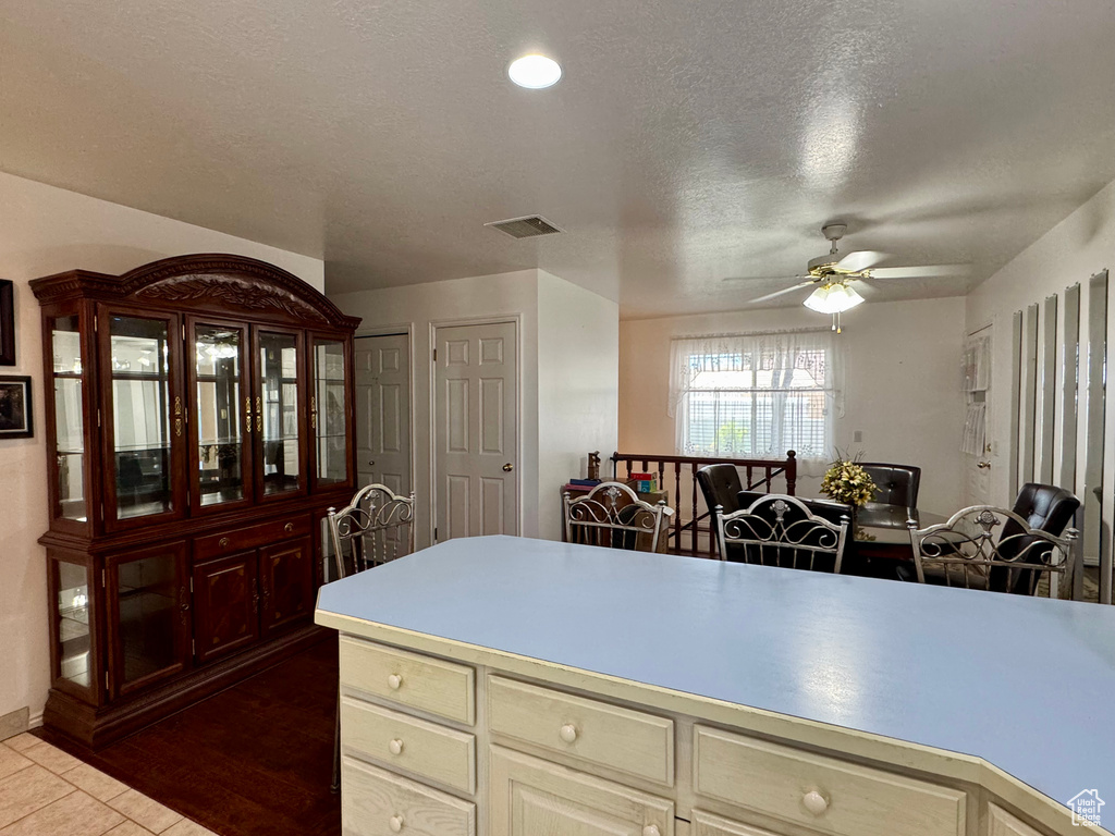 Kitchen featuring ceiling fan, light countertops, tile patterned floors, a textured ceiling, and cream cabinets