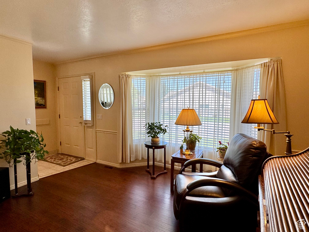 Foyer with wood finished floors, crown molding, and baseboards