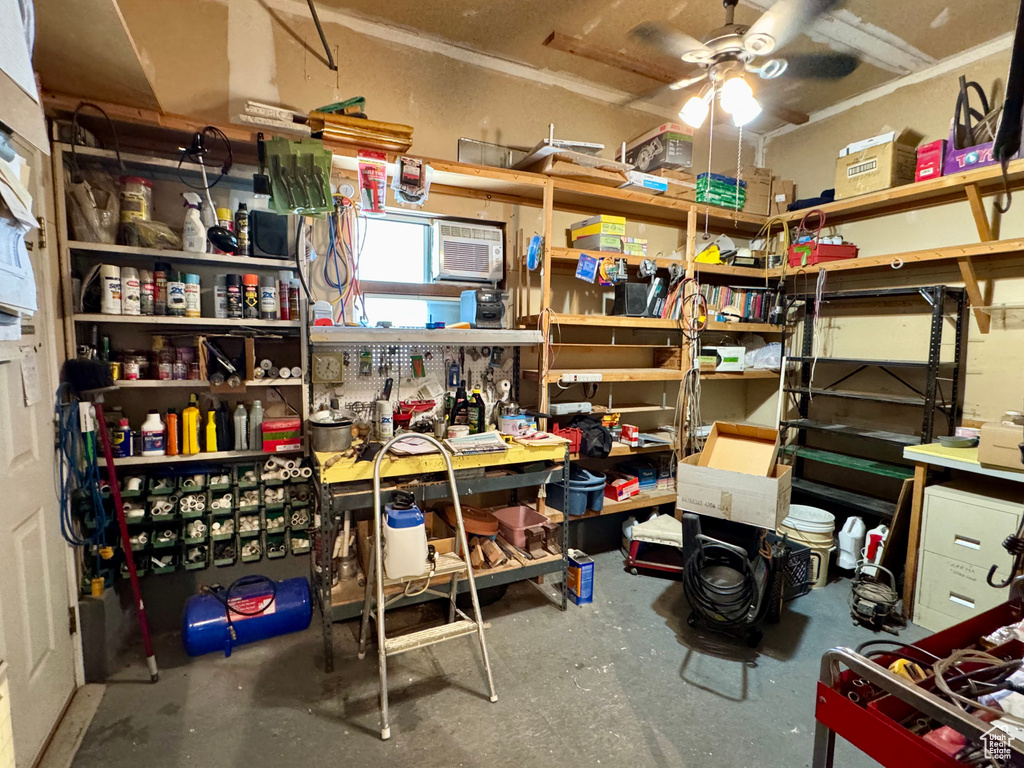 Storage room featuring a ceiling fan and a wall unit AC