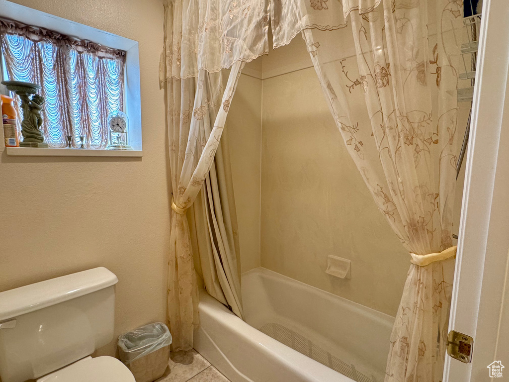 Full bath with shower / bath combo, toilet, and tile patterned flooring