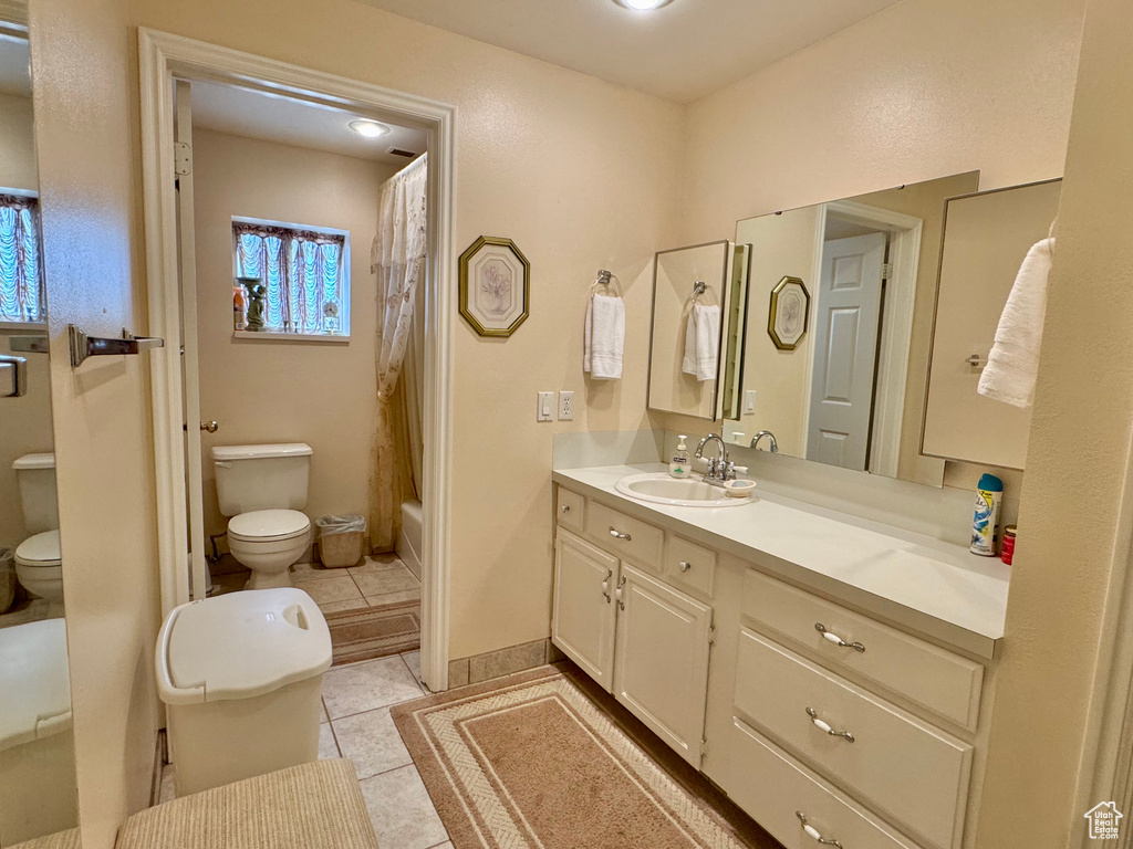 Bathroom with toilet, vanity, tile patterned flooring, and shower / bath combo