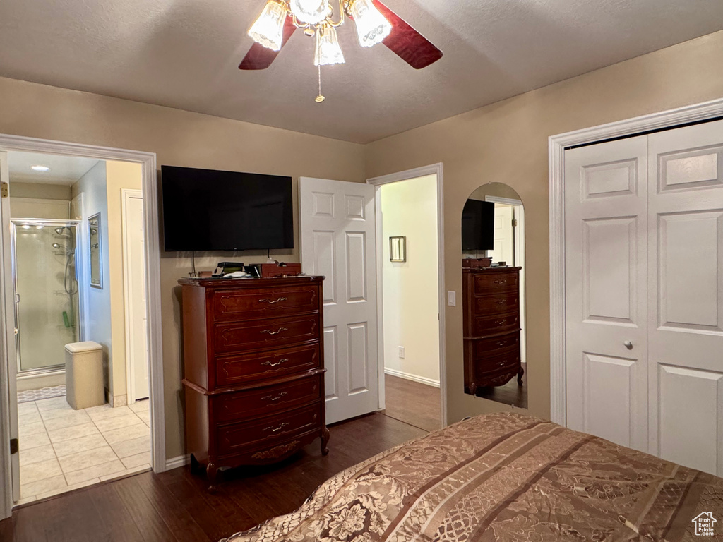 Bedroom featuring dark wood-style floors, arched walkways, baseboards, and a closet