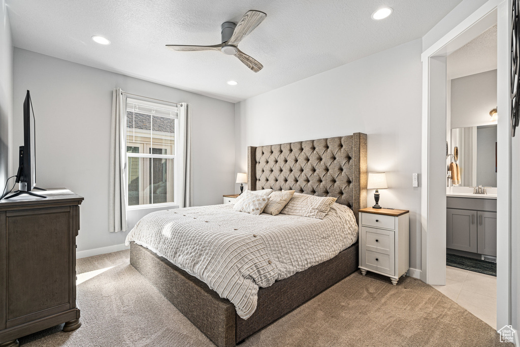Bedroom with light carpet, recessed lighting, ensuite bathroom, ceiling fan, and baseboards