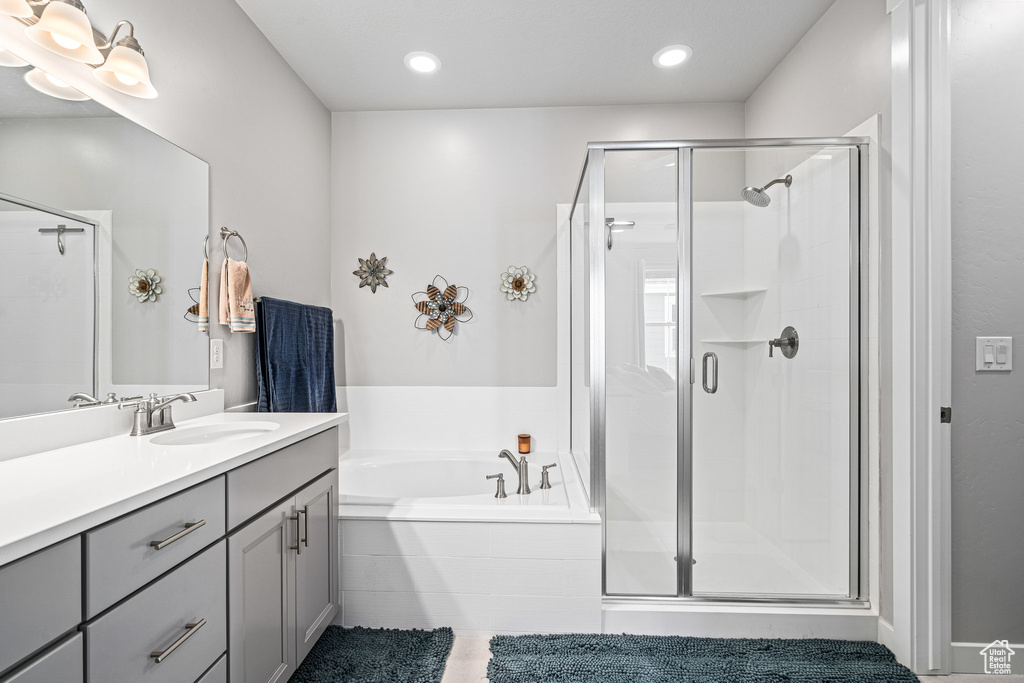 Full bathroom with vanity, a bath, a stall shower, and recessed lighting