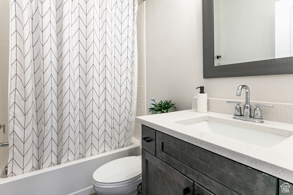 Bathroom featuring shower / bath combination with curtain and vanity