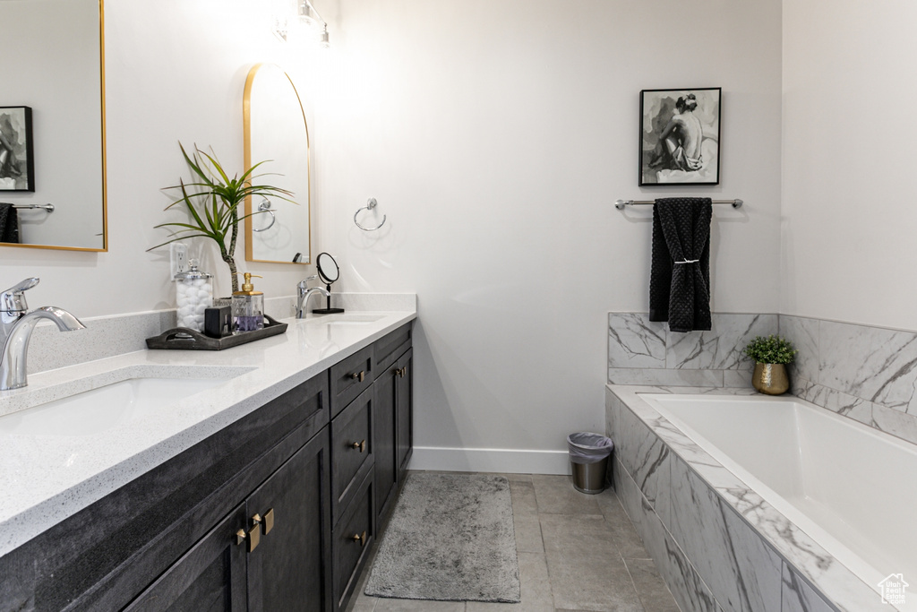 Full bathroom featuring double vanity, a bath, and tile patterned floors