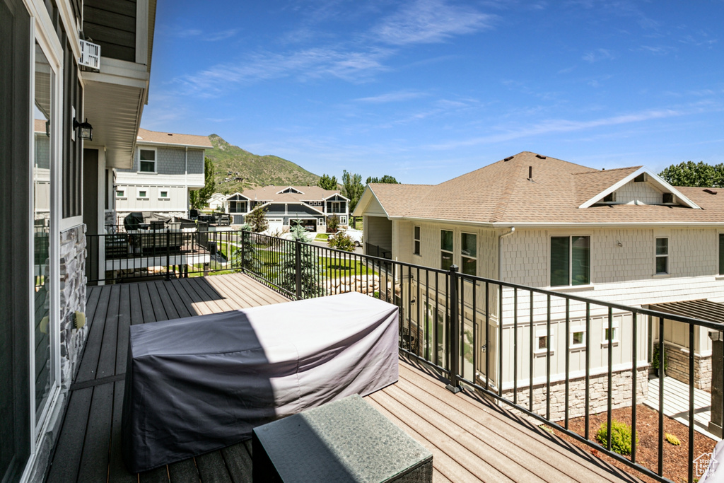 Wooden deck featuring a residential view and a mountain view