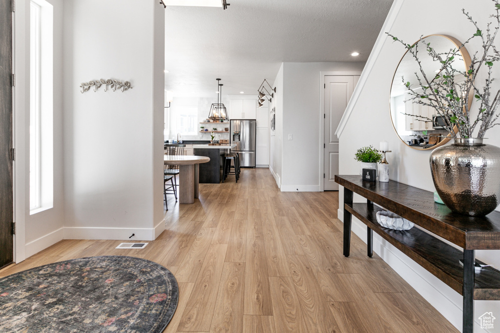 Entrance foyer with light wood finished floors and recessed lighting