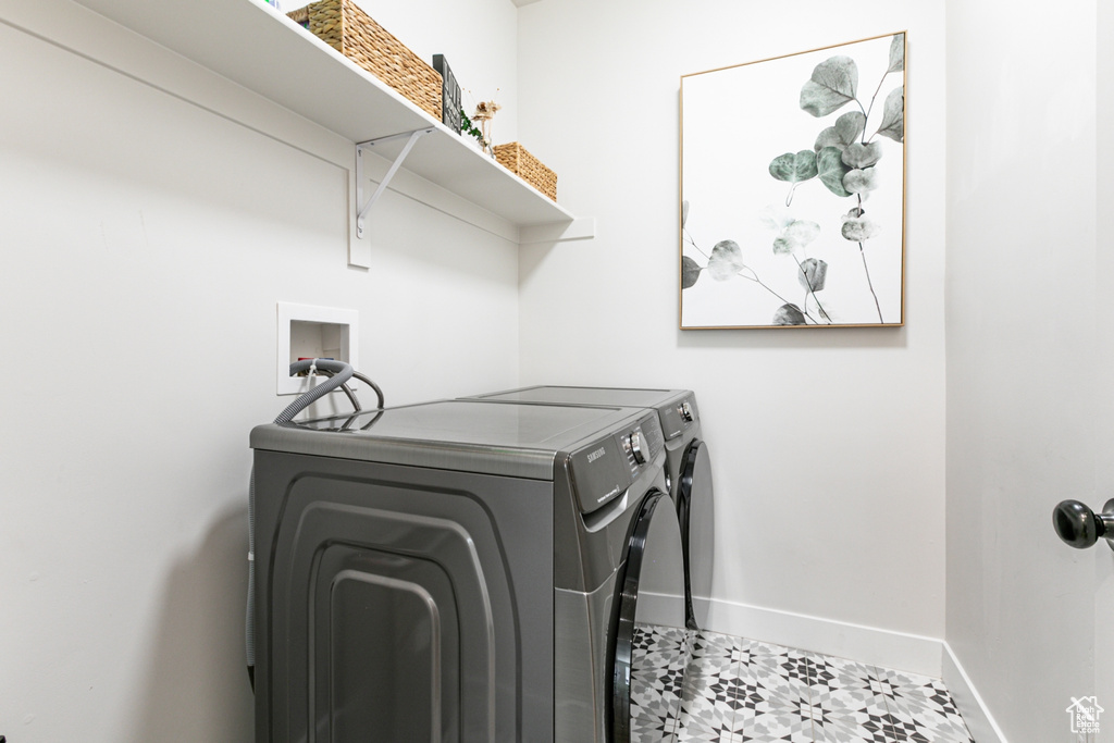 Laundry room with independent washer and dryer and tile patterned floors