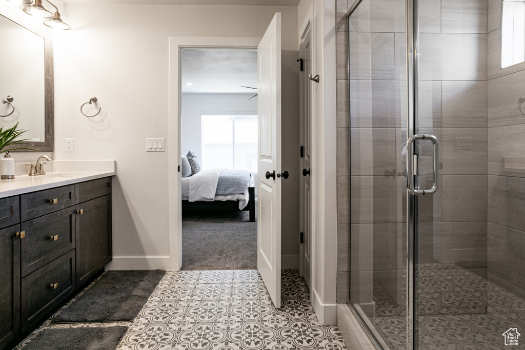 Bathroom with vanity, plenty of natural light, ensuite bath, and a stall shower