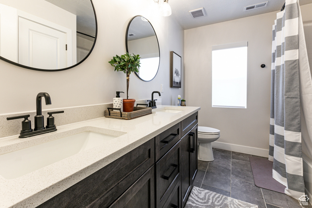 Full bath with double vanity and toilet