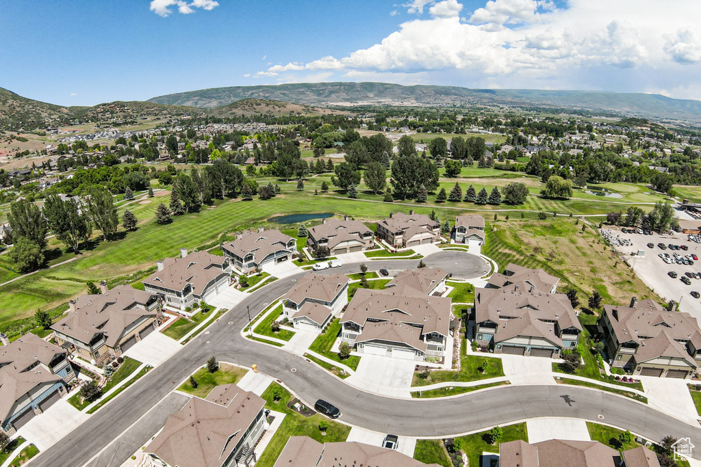 Aerial view of property and surrounding area with nearby suburban area and a mountainous background