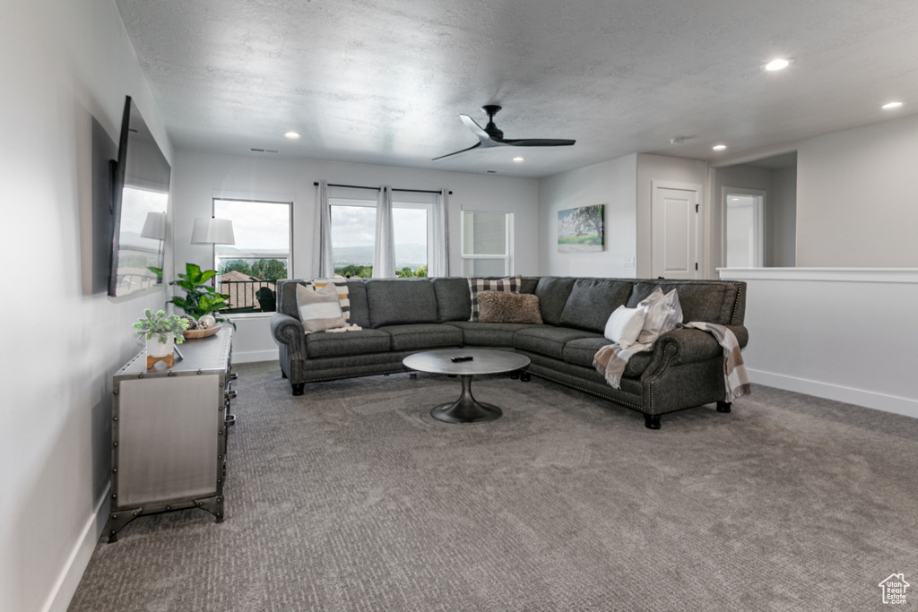 Living area with carpet, a ceiling fan, and recessed lighting