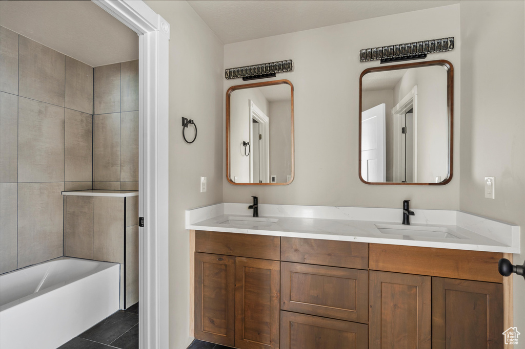 Bathroom with double vanity and tile patterned flooring