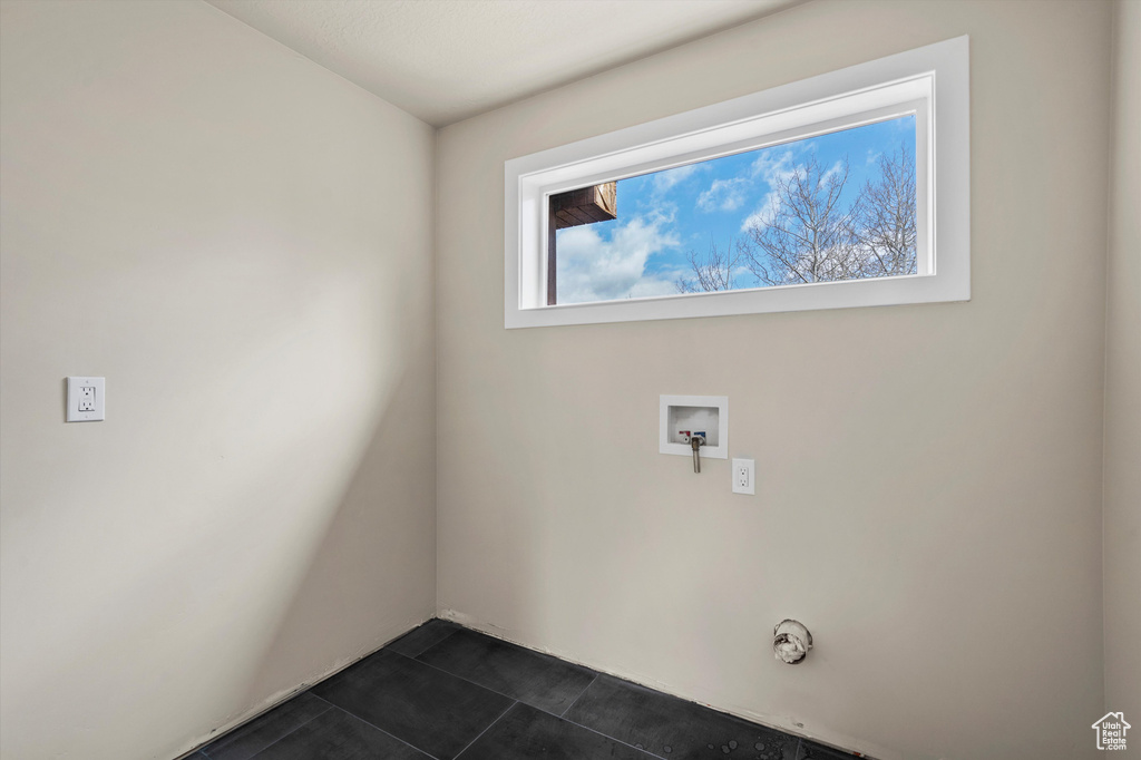 Laundry room featuring washer hookup and dark tile patterned floors