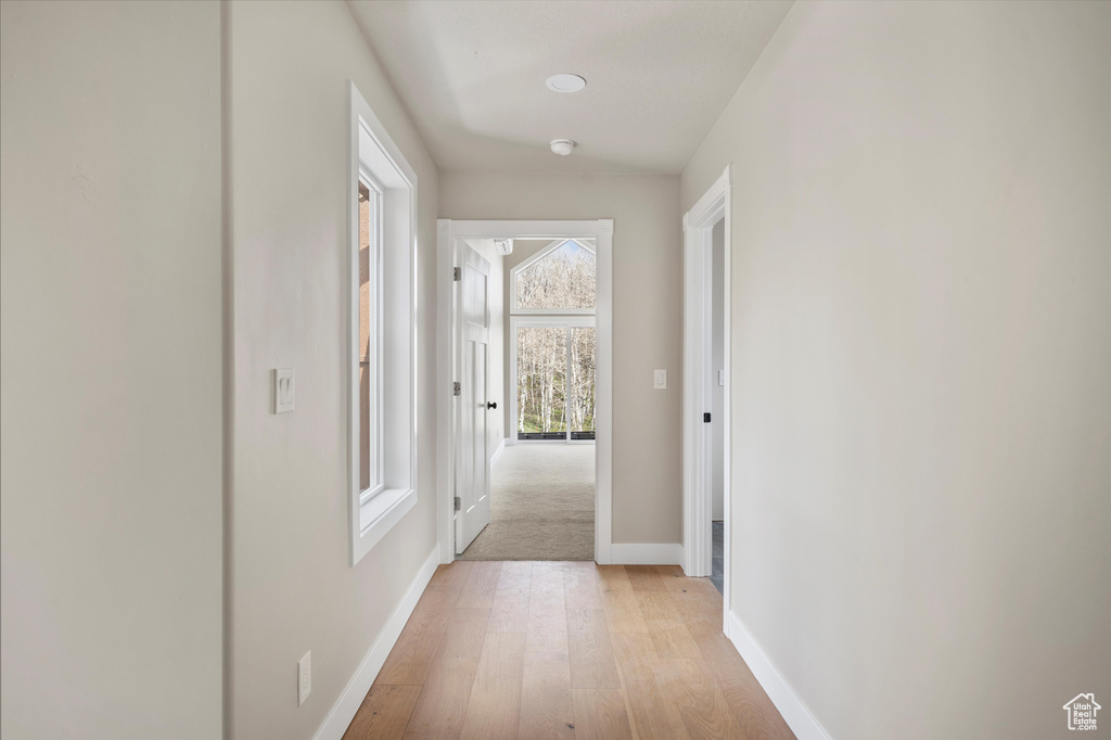 Hallway with light wood-style flooring and baseboards