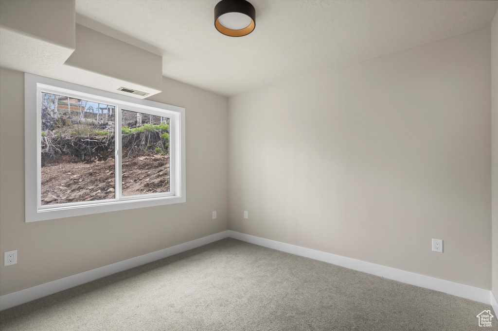 Carpeted empty room featuring baseboards