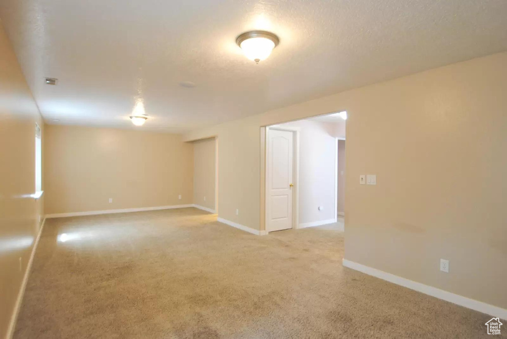 Spare room featuring light carpet and baseboards