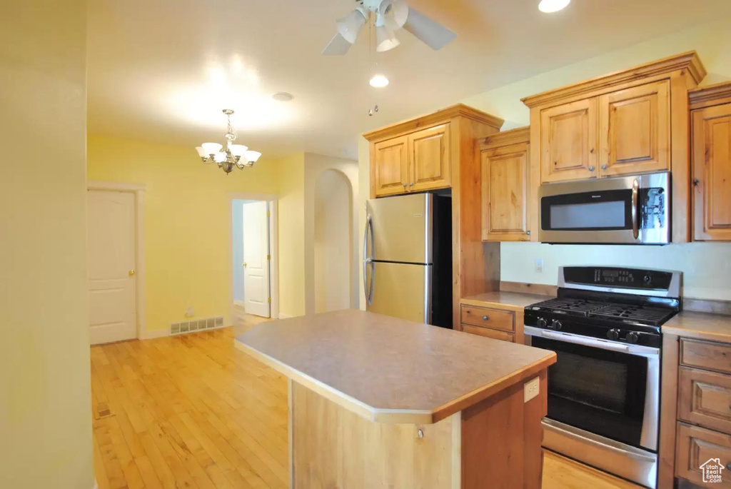Kitchen featuring stainless steel appliances, a kitchen island, a chandelier, recessed lighting, and light wood finished floors