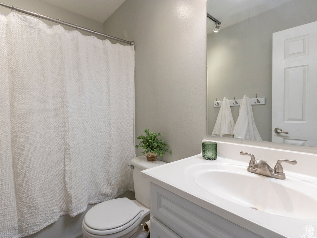 Bathroom with vanity, toilet, and a shower with shower curtain
