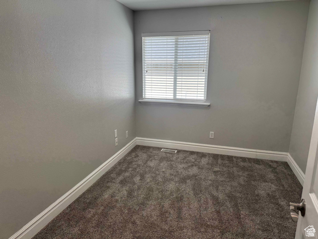Carpeted spare room with baseboards