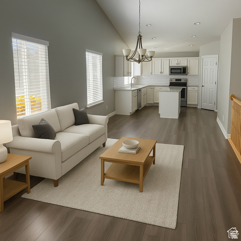 Living area with a chandelier, baseboards, dark wood-type flooring, vaulted ceiling, and recessed lighting