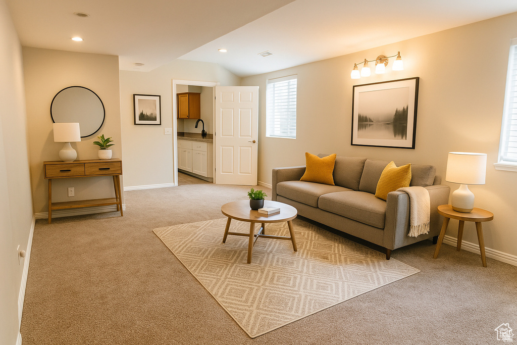 Living area with light carpet, baseboards, and recessed lighting