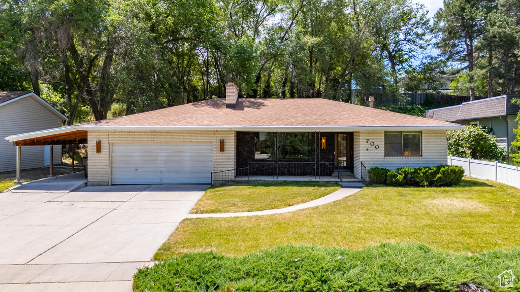 Single story home with brick siding, concrete driveway, a chimney, covered porch, and an attached garage