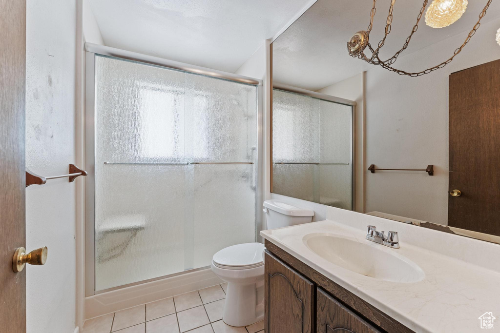 Bathroom with tile patterned floors, vanity, a shower stall, and toilet