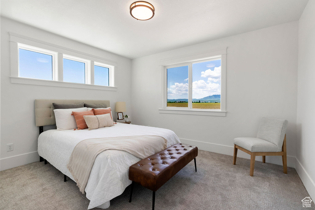 Bedroom featuring light carpet and baseboards