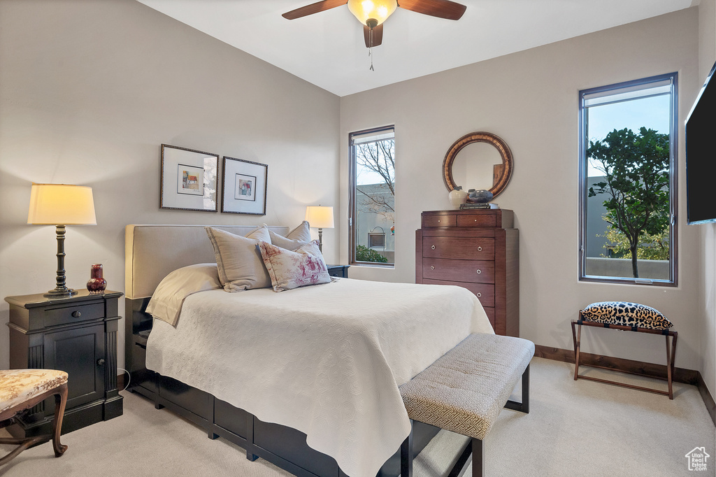 Bedroom featuring ceiling fan, baseboards, and light colored carpet