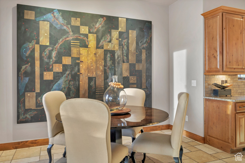 Dining area featuring light tile patterned floors and baseboards