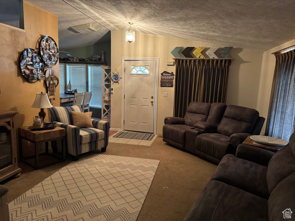 Carpeted living room with lofted ceiling and a textured ceiling