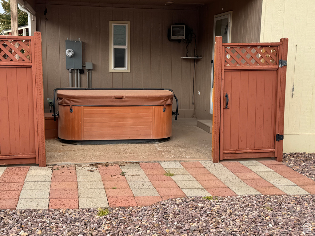 View of patio / terrace featuring a hot tub and a gate