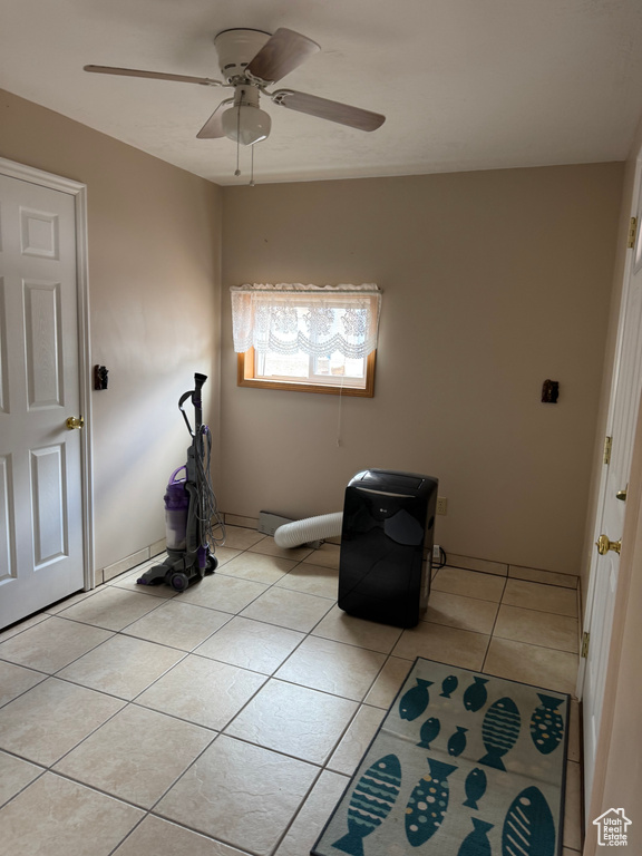 Spare room featuring ceiling fan and light tile patterned floors