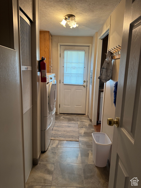 Laundry area with cabinet space, separate washer and dryer, and a textured ceiling
