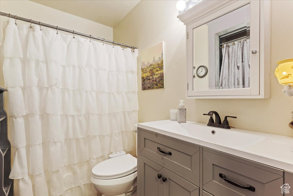 Bathroom featuring vanity, toilet, and a shower with curtain