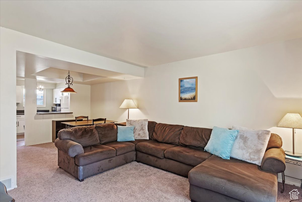 Living area featuring light colored carpet and baseboards