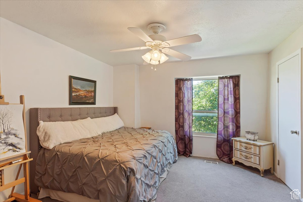Carpeted bedroom featuring a ceiling fan