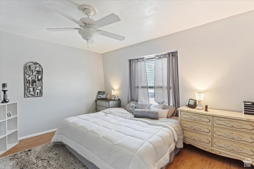 Bedroom with light wood-style floors, ceiling fan, and baseboards
