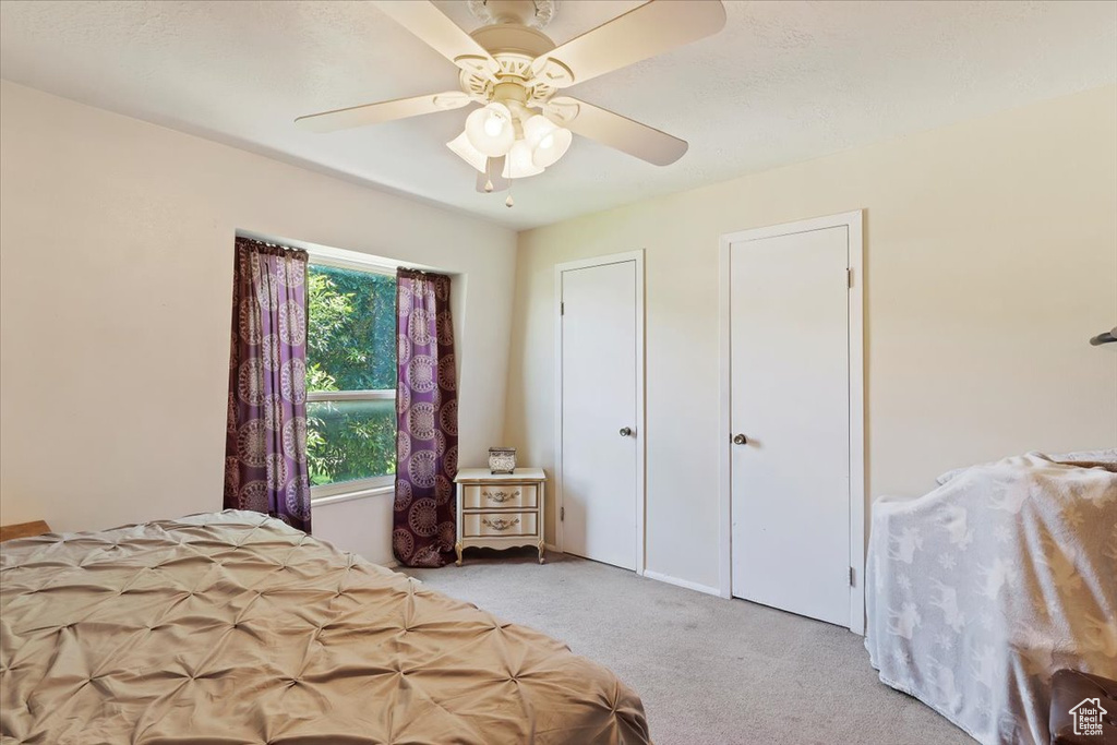 Carpeted bedroom featuring ceiling fan
